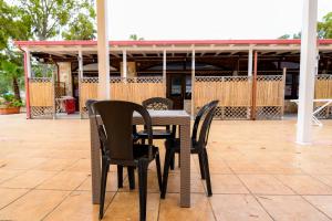 a table and four chairs on a patio at Giardini Sausari Residence in Punta Prosciutto