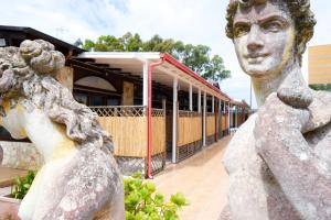 a statue of a boy in front of a building at Giardini Sausari Residence in Punta Prosciutto