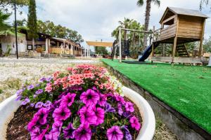 a flower bed in a park with a playground at Giardini Sausari Residence in Punta Prosciutto