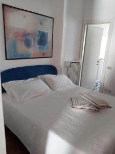 een slaapkamer met een wit bed met een blauw hoofdeinde bij Gatto Bianco Bergamo 9 in Bergamo