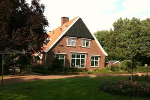 a red brick house with a black roof at Bed & Breakfast Notterveld in Notter