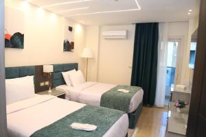 a hotel room with two beds and a window at Jewel Agouza Hotel in Cairo +108 photos