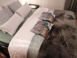 a bed with three pillows on top of it at Bella apartment in Belgrade