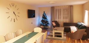 a living room with a christmas tree in the corner at Chałupka Apartament in Nowa Biała