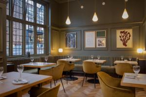 圣奥尔本斯The Samuel Ryder Hotel St Albans, Tapestry Collection Hilton的有桌椅和窗户的餐厅