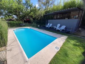 - une piscine dans l'arrière-cour d'une maison dans l'établissement PIEDRALAGO CABAÑAS Y TURISMO, à Villa Carlos Paz