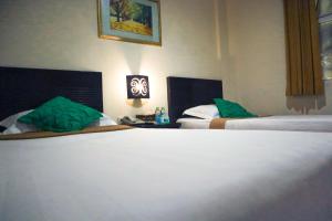 A bed or beds in a room at Helios Hotel Malang