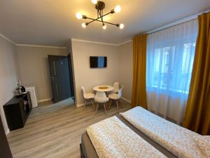 1 dormitorio con 1 cama, mesa y sillas en B&B Home, en Sighişoara