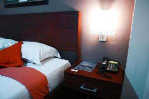 A bed or beds in a room at Helios Hotel Malang
