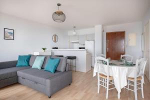 a living room and kitchen with a couch and a table at Très bel appartement avec vue sur mer à Pornichet in Pornichet +10 photos