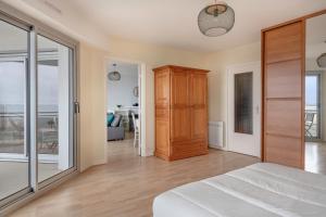 a bedroom with a bed and a sliding glass door at Très bel appartement avec vue sur mer à Pornichet in Pornichet