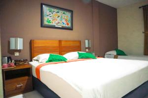 A bed or beds in a room at Helios Hotel Malang