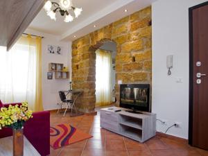 sala de estar con TV y pared de ladrillo en La Cupola, en Palermo