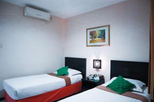 A bed or beds in a room at Helios Hotel Malang