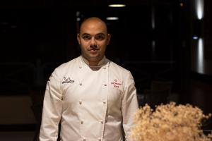 uno chef in piedi accanto a un mucchio di cibo di Hotel Villa Rosario II, Edificio Moderno a Ribadesella
