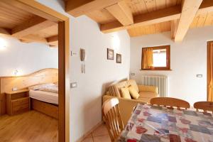 Zimmer mit einem Bett, einem Tisch und einem Sofa in der Unterkunft Appartamento Cima Fopel in Livigno
