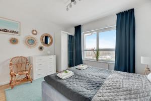 a bedroom with a bed and a chair and a window at Baltica Panorma View by TriApart in Gdańsk