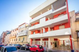 un bâtiment avec des voitures garées dans un parking dans l'établissement Ogliastra Apartment Rooms, à Cagliari