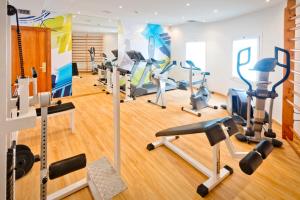 un gimnasio con cintas de correr y equipos de ejercicio en una habitación en GHT Maritim, en Calella