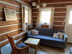 a living room with a blue couch and wooden walls at Modern chalet Na Zlatníku in Zlatá Olešnice