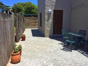 a patio with a table and chairs and a fence at 8 On Main in Witsand