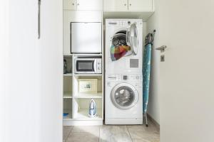 uma lavandaria com uma máquina de lavar roupa e uma máquina de lavar roupa em Ferienhaus Gesoeders Hus em Sankt Peter-Ording