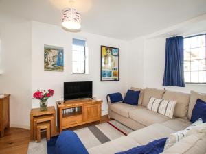 a living room with a couch and a tv at Broad Leys in Swanage