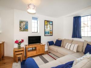 a living room with a couch and a tv at Broadleys in Swanage