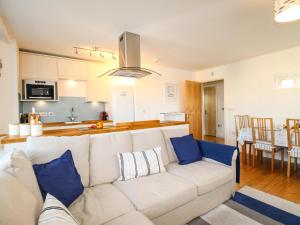 a living room with a white couch and a kitchen at Broad Leys in Swanage