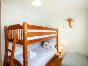 a bedroom with a bunk bed with a ladder at Broadleys in Swanage