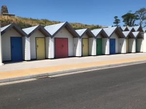 a row of beach huts with colorful doors on a street at Broadleys in Swanage