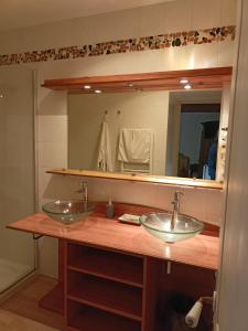 La salle de bains est pourvue de 2 lavabos et d'un miroir. dans l'établissement Au Fond de la Cour, à Veyre-Monton