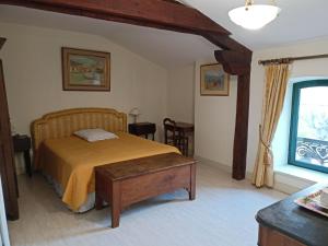 a bedroom with a bed and a table and a window at Au Fond de la Cour in Veyre-Monton