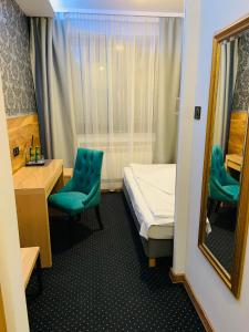 a small room with a bed and a mirror at A&P Motel in Mikołów