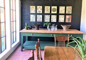 a kitchen with a table, chairs and a vase of flowers at De Oude Schuur in Stellenbosch