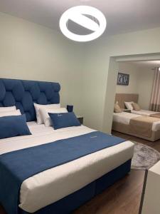 een slaapkamer met 2 bedden met een blauw hoofdeinde bij Essy's Apartment in Korçë