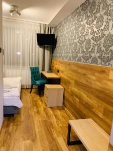 um quarto com 2 camas, uma secretária e uma cadeira em A&P Motel em Mikolów