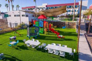 a playground with tables and chairs on the grass at Sawari Hotel in San Carlos