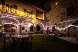 an outdoor patio with tables and chairs and christmas lights at Castello di Zorzino Iseo lake in Riva di Solto