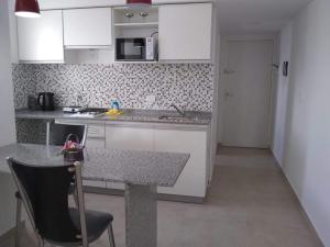 cocina con armarios blancos y encimera en Pasco 1847 Apartamento 5B en Rosario