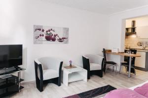 a living room with a table and chairs and a kitchen at Apart-2-OG-Nr1 in Darmstadt