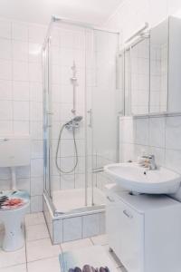 baño blanco con ducha y lavamanos en Apart-2-OG-Nr1, en Darmstadt