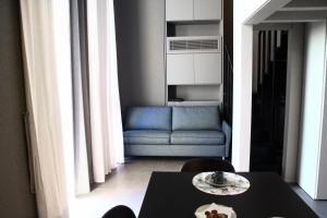 a living room with a table and a blue couch at Dimore al Te in Mantova