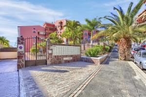アロナにあるEl Mocan de Thiago Palm Marの門とヤシの木と建物のある通り