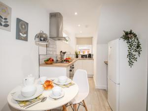 een keuken met een witte tafel en een witte koelkast bij Portside in Weymouth