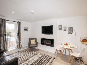 a living room with a fireplace and a table at Portside in Weymouth
