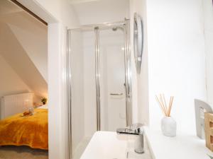 a white bathroom with a shower and a bed at Portside in Weymouth +16 photos
