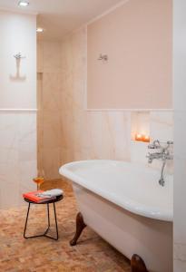 a bathroom with a tub and a stool at Leopolis Hotel in Lviv