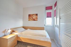 ein kleines Schlafzimmer mit einem Bett und einem Fenster in der Unterkunft Grömitz Center II Wohnung 25 in Grömitz