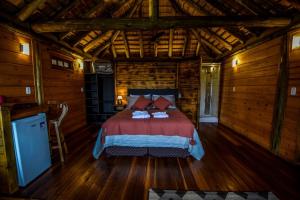 a bedroom with a bed in a wooden cabin at Refugio monte itapeva in Torres